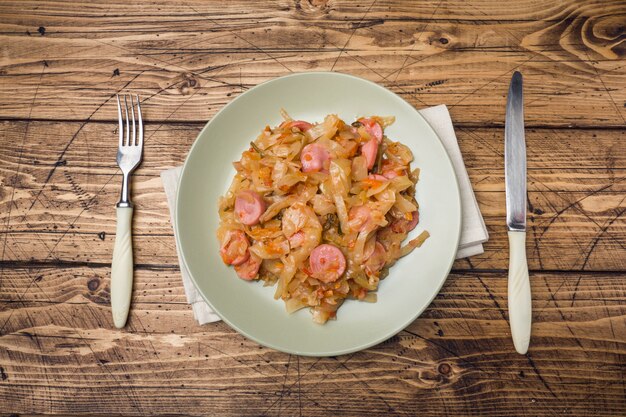 Col estofada con salchichas en un plato sobre la mesa.