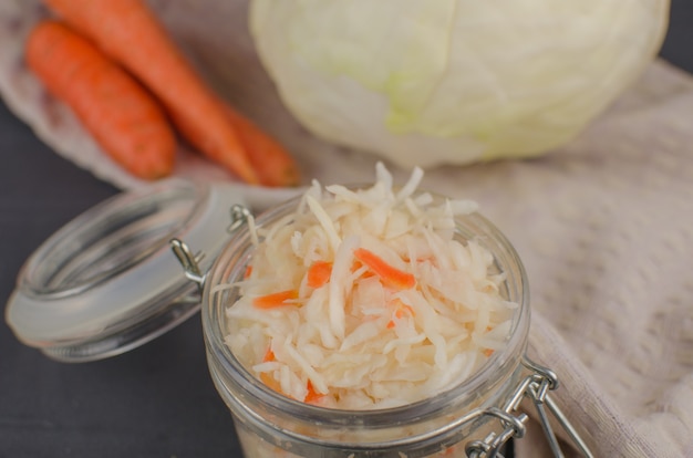 Col fermentada - Chucrut con hierbas y especias en el fondo de madera. Comida fermentada. Copia espacio