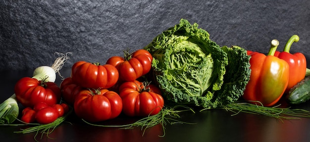 Col rizada fresca paprika pepino cebolla verde tomates sobre fondo gris Vista superior concepto de desintoxicación comida vegana ingredientes para cocinar