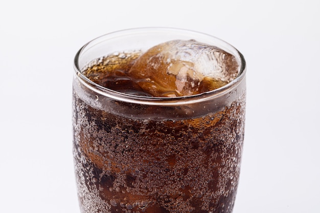 Cola em copo com cubos de gelo transparentes isolados no fundo branco