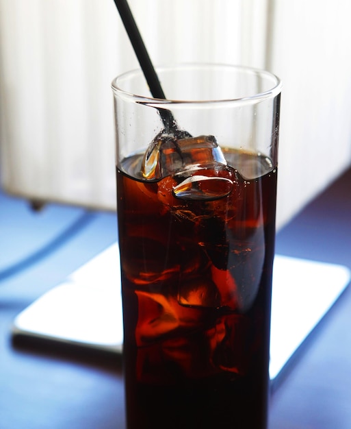 Cola-Glas mit Eiswürfeln auf dem Tisch