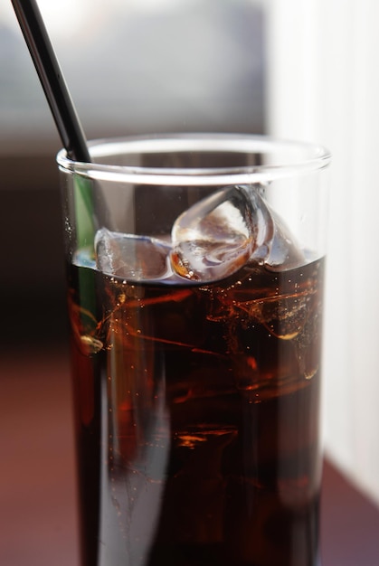 Cola-Glas mit Eiswürfeln auf dem Tisch