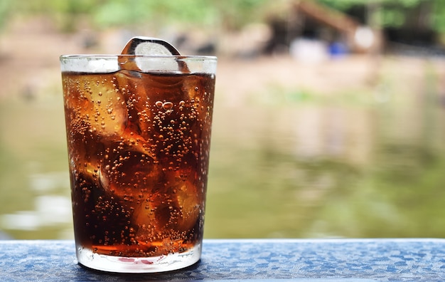 Foto cola y hielo en vaso en tiempo de relax en vacaciones