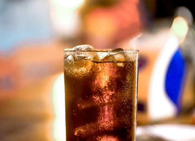 Cola kühlt im Glas mit weißen Zwiebeln