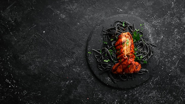 Cola de langosta al horno en salsa de ajo y pasta negra con tinta de sepia Comida de restaurante de lujo Mariscos Estilo rústico Flat Lay