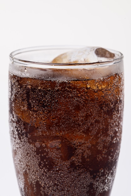 Foto cola en vaso con cubitos de hielo transparente aislado sobre fondo blanco.