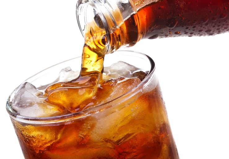 Foto cola se vierte en vidrio en blanco