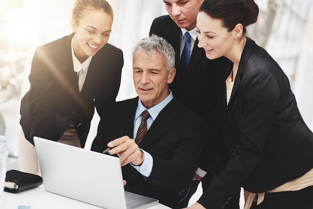 Foto colaboración del ceo y la computadora portátil con los empleados en la oficina para la lluvia de ideas para la compañía mujeres felices y hablando con el jefe para el liderazgo del negocio con tecnología para la estrategia en línea e internet