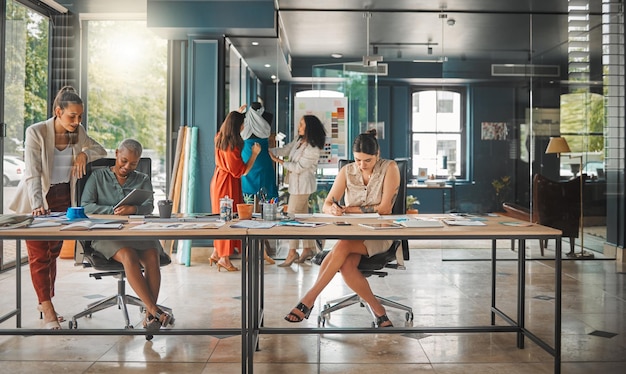 Colaborações trazem novas ideias. Foto de um grupo de designers femininas trabalhando em um escritório.