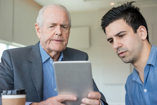 Colaboradores concentrados usando o tablet no escritório