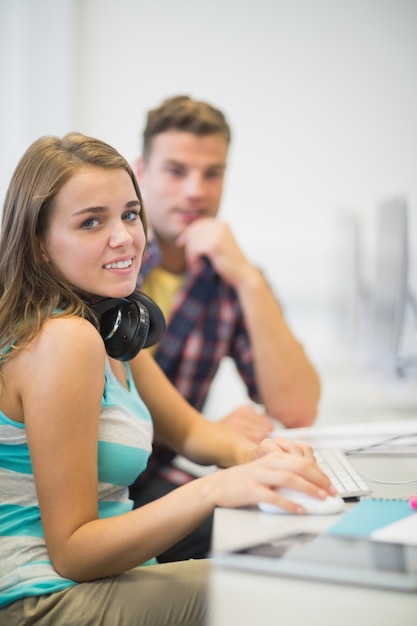 Colaboradores felizes fazendo uma tarefa juntos na sala de informática