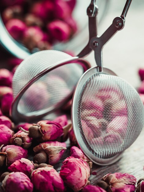 Foto colador de té de capullos de rosa y primer plano de tarro de vidrio enfoque selectivo