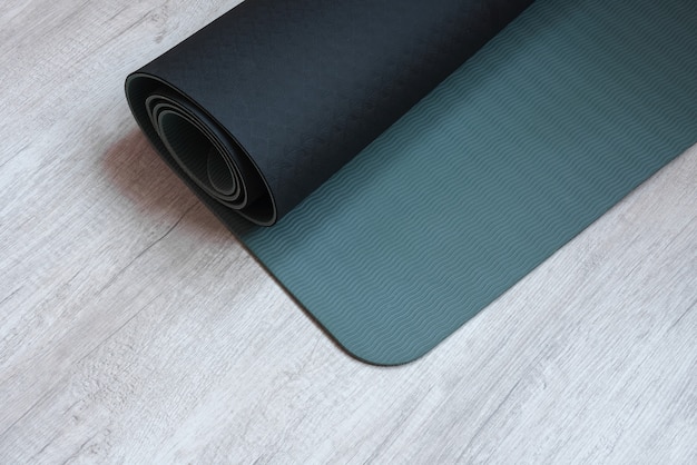 Colchoneta de ejercicios en el fondo de madera clara para practicar yoga fitness y otras actividades físicas Concepto de estilo de vida activo y saludable