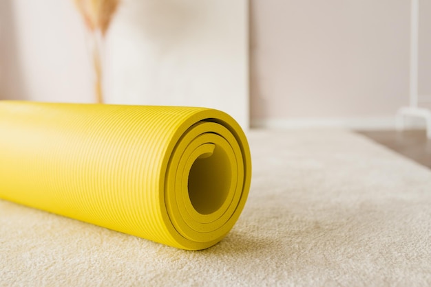 Colchoneta de yoga amarilla en casa o en el estudio