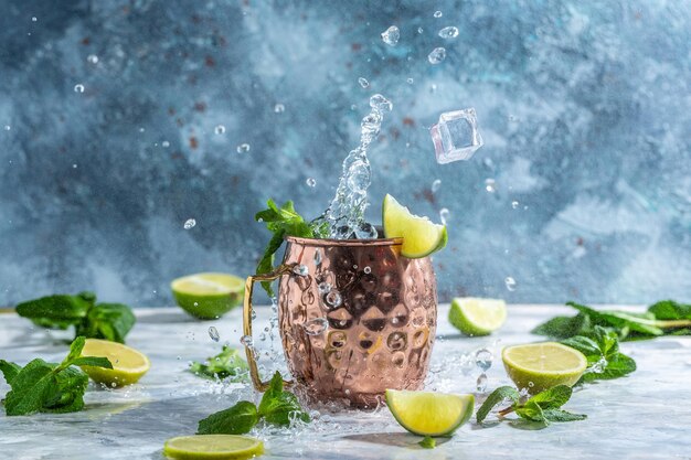 Cold Moscow Mules Cocktail mit Ginger Beer Wodka Limettenspritzern und eisgefrorener Bewegung