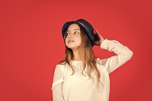 Coleção de acessórios de verão de moda vintage, beleza e estilo de cabelo comprido de criança pequena seguindo seu estilo pessoal menina retrô fundo vermelho criança bonita com chapéu retrô