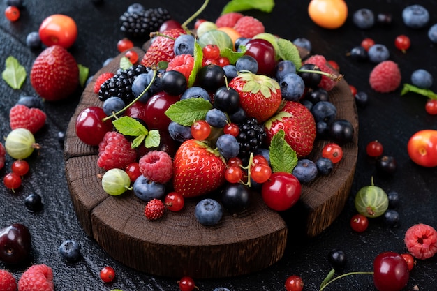 Coleção de frutos silvestres na superfície preta, vista superior