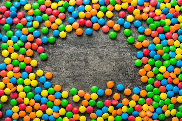 Coleção mista de doces coloridos em fundo colorido Quadro de visão superior plana de doces revestidos de chocolate coloridos