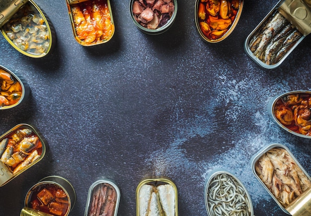 Foto una colección de alimentos enlatados en latas sobre un fondo oscuro