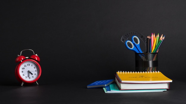 Colección colorida de útiles escolares en fondo negro. De vuelta a la escuela. grandes ideas