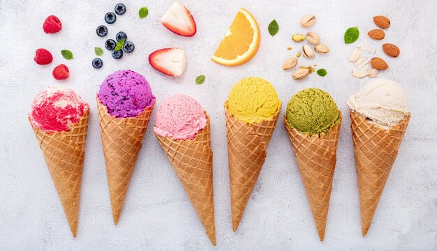 Foto colección de conos de helado planos laicos sobre fondo de piedra oscura.