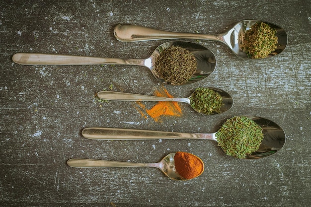 Foto una colección de cucharas con especias y una de ellas tiene una especia verde.