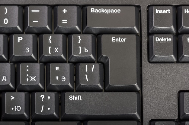 Foto colección electrónica - teclado de computadora negro de primer plano con letra rusa y tecla enter