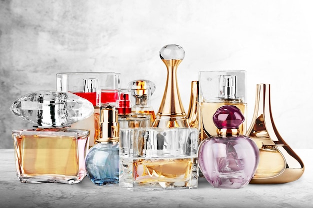 Colección de frascos de perfume de vidrio coloreado en el escritorio.