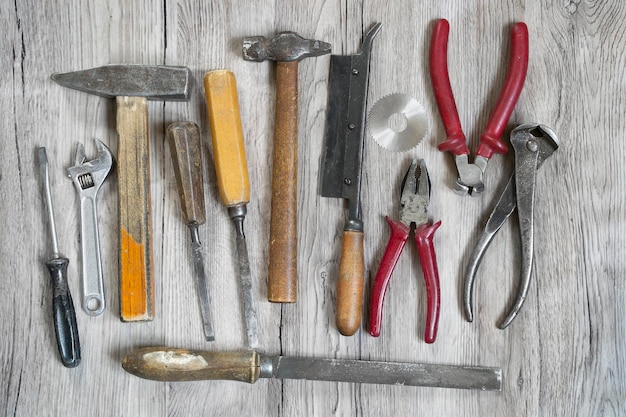 Colección de herramientas de mano antiguas sobre fondo de madera