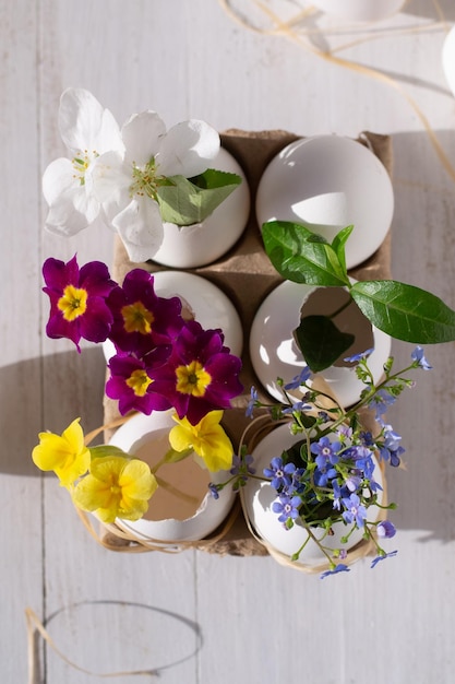 Foto una colección de huevos con flores sobre una mesa de madera.