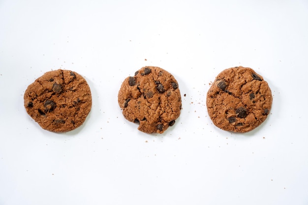 Colección de medias galletas con trocitos de chocolate sobre fondo blanco.