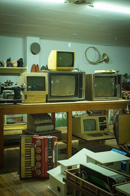una colección de monitores de computadora viejos están en un estante