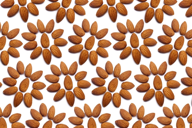 Una colección de nueces de almendras peladas se encuentra en forma de círculo o sol sobre un fondo blanco aislado con un camino de recorte Patrón de almendras peladas