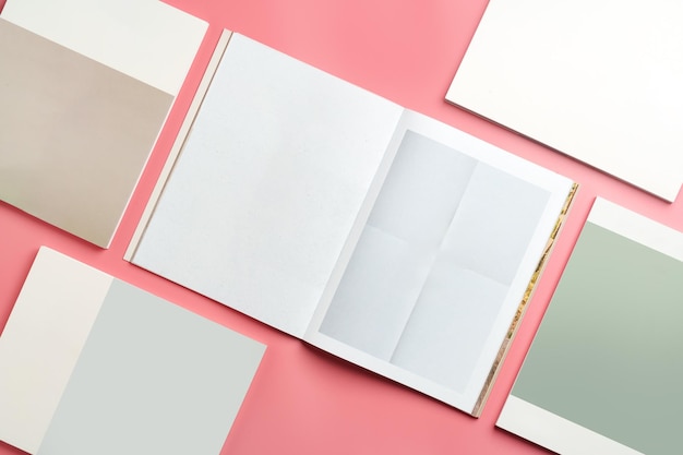 Una colección de papeles en blanco apilados en una superficie rosada para proyectos creativos