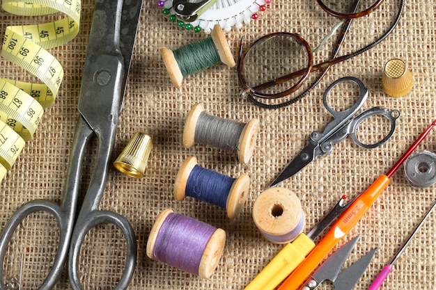 Una colección de suministros de costura que incluye un par de tijeras, anteojos, anteojos y anteojos.
