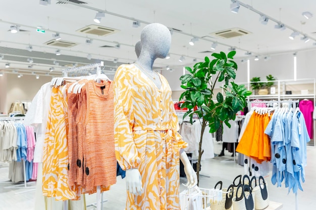 Colección de verano de ropa de mujer en la tienda en un maniquí y perchas Vestidos de luz brillante blusas y faldas Estilo y moda