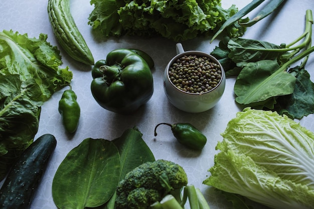 Colección de verduras frescas verdes y alimentos crudos planos, estilo de vida saludable.