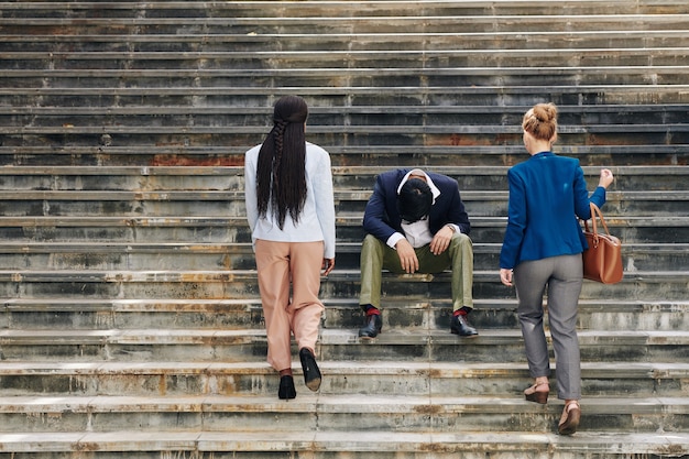 Colega de trabalho estressada sentada nos degraus