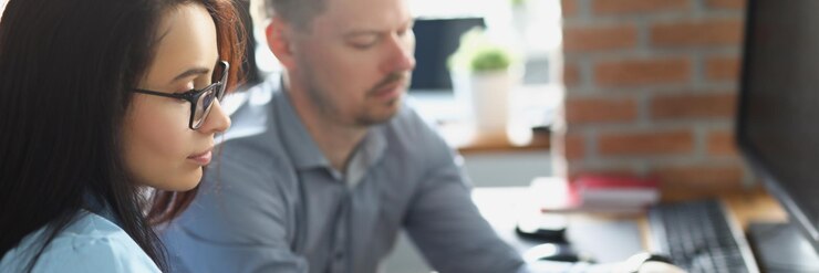 Foto un colega masculino ayuda a una compañera de trabajo con el trabajo a explicar en la corporación de la vida de la oficina de la computadora portátil