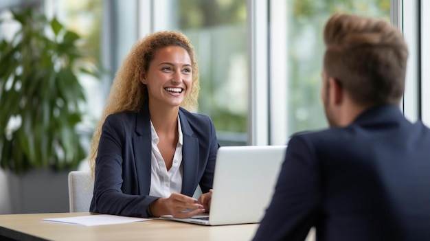 Foto colega sonriente mirando a la mujer de negocios en el escritorio en la oficina