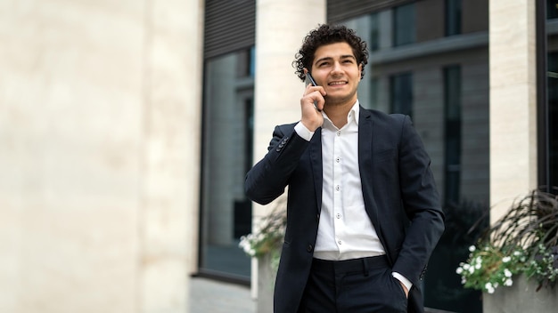 Un colega de trabajo está llamando Un gerente masculino con traje oficial tiene un teléfono en sus manos