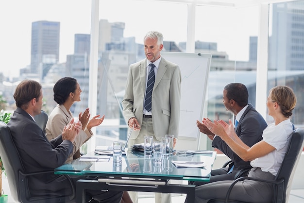 Colegas aplauden al jefe durante una reunión