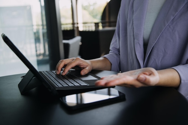 Colegas asiáticos homem e mulher discutindo e trabalhando com laptop na mesa de escritório no escritório