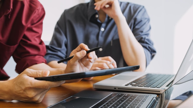 Colegas asiáticos homem e mulher discutindo e trabalhando com laptop na mesa de escritório no escritório