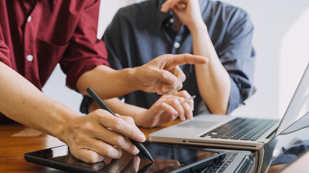 Colegas asiáticos homem e mulher discutindo e trabalhando com laptop na mesa de escritório no escritório