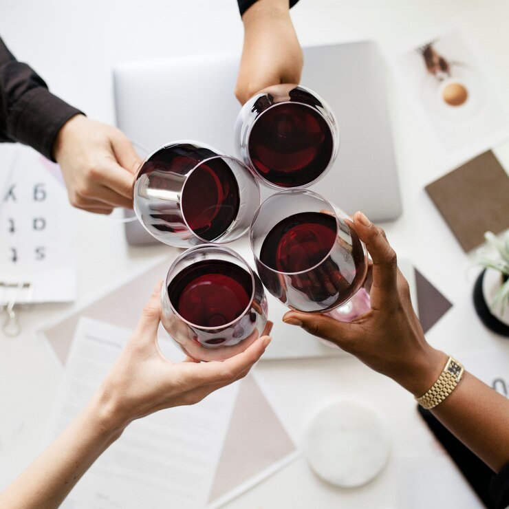 Colegas brindando copas de vino en el trabajo