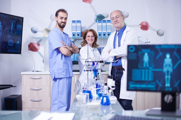 Colegas científicos sonrientes en su uniforme de pie en el laboratorio químico. Equipo de laboratorio.