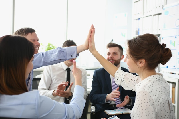 Los colegas dan el gesto de chocar los cinco para celebrar el final del proyecto de la empresa