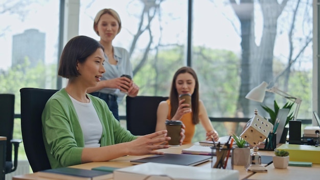 Colegas de empresa amigáveis a desfrutar de uma pausa no escritório, colegas de trabalho a conversar.