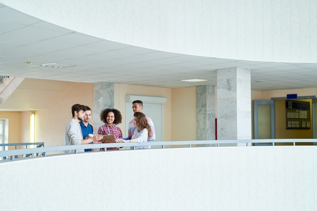 Colegas de grupo positivos que discutem assuntos no salão